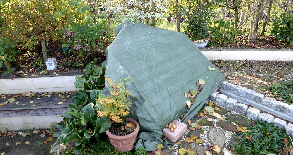 Gartenbrunnen mit Folie winterfest abgedeckt