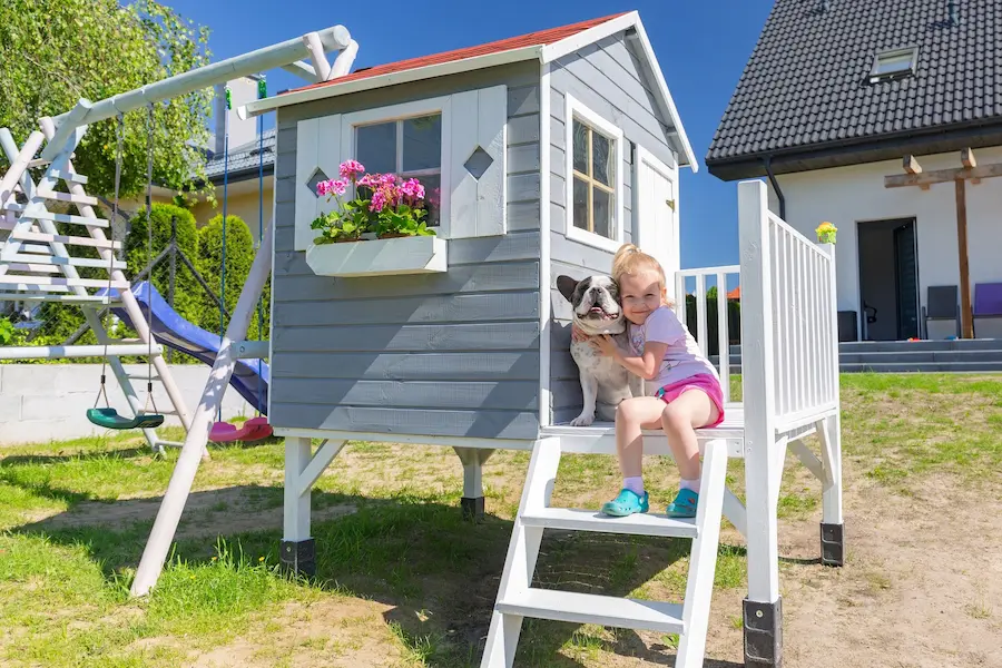 Kind mit Hund im Spielplatz im Garten